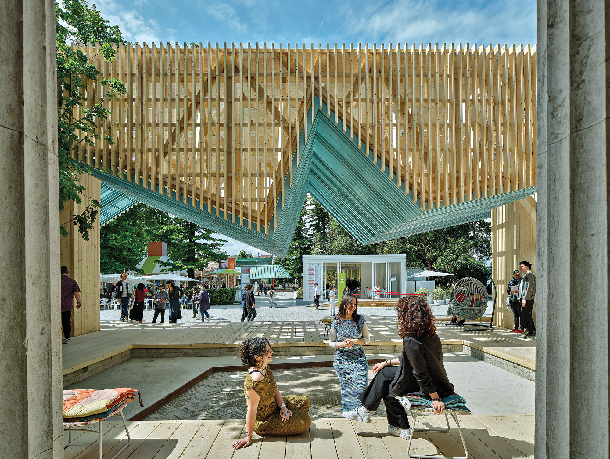 People hanging out under the porch at the american pavillion in the venice bienalle designed by Marlon Blackwell Architects.