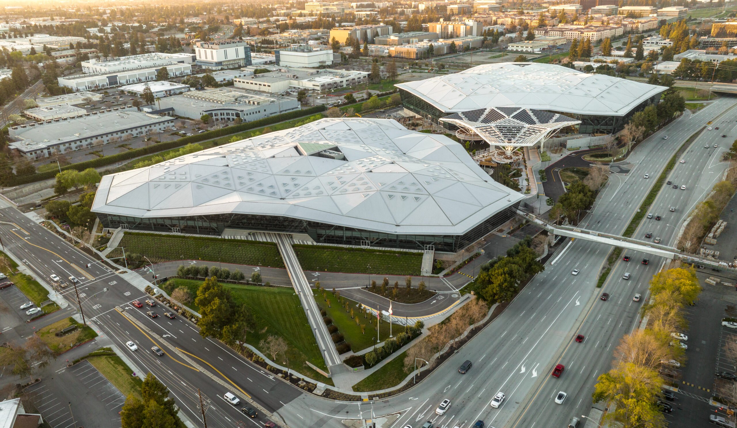 A top aerial view of a LEED Gold NVIDIA campus is anchored by a a large striking steel canopy, forming a unified identity across two geometric buildings.
