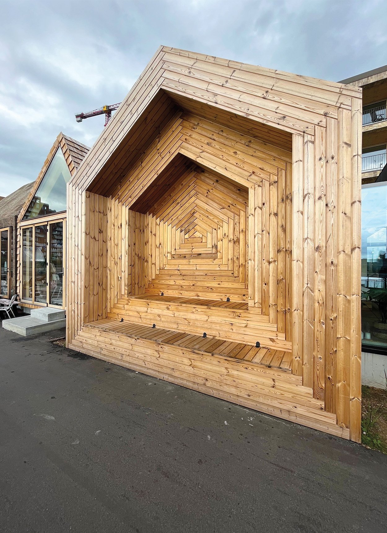 A house shaped wood facade made from discarded pine wood waste ready to be installed in an A frame home.